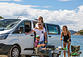 Freunde stehen neben dem Wohnmobil und machen Mittagessen, als sie in Slano anhalten, um einen Tag am Strand zu genießen; Slano, Gespanschaft Dubrovnik-Neretva (Dubrova?ko-neretvanska ?upanija), Kroatien