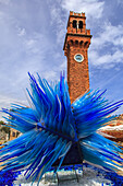 Alter Uhrenturm und die blaue Glasskulptur Cometa di Vetro (Comet Glass Star); Murano, Venetien, Italien.