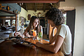 Zwei weibliche Reisende sitzen an einem Tisch in der Bar, unterhalten sich und trinken auf der Gabus Game Ranch; Otavi, Otjozondjupa, Namibia.