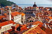 Kuppeln des Uhrenturms, der St.-Blasius-Kirche und der Dubrovniker Kathedrale zwischen den Terrakotta-Dächern der Altstadt mit Blick auf die Adria; Dubrovnik, Dalmatien, Kroatien.