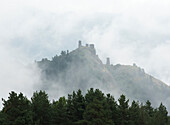 Nebel umhüllt die mittelalterliche Festung und die Turmhäuser von Keselo oberhalb des Dorfes Omalo im Tuscheti-Nationalpark; Omalo, Kachetien, Georgien.