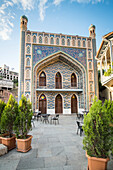 Sitting area in front of the mosaic tiled, mosque-like facade of the Orbeliani Baths, one of the most popular sulfuric bath houses in the Abanotubani District in the Old Town; Tbilisi, Georgia