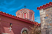 Close-up of ornate dome and clay tile rooftop with brick and stone exterior of The Chapel of St Nicholas at St Anthony's Greek Orthodox Monastery; Florence, Arizona, United States of America
