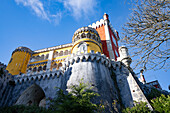 Das auf einem Hügel gelegene Schloss Palacio Da Pena mit seinen bunten Türmen und der Steinmauer in den Sintra-Bergen; Sintra, Bezirk Lissabon, Portugal.