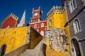 Das auf einem Hügel gelegene Schloss Palacio Da Pena mit seinen bunten Türmen und der Steintreppe in den Sintra-Bergen; Sintra, Bezirk Lissabon, Portugal.