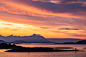 Mitternachtssonne am Polarkreis mit einem dramatischen Himmel in der Dämmerung; Lofoten, Polarkreis, Norwegen