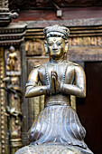 Close-up of a brass statue of a praying figure in Kwa Bahal Golden Temple in the old city of Patan or Lalitpur built in the twelfth century by King Bhaskar Varman in the Kathmandu Valley; Patan (Lalitpur), Kathmandu Valley, Nepal