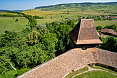 Dach der befestigten sächsischen Kirche von Viscri mit ihrer Steinmauer und Überblick über das Dorf; Viscri, Kreis Brasov, Siebenbürgen, Rumänien.