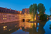 Die Pegnitz fließt durch Nürnberg zur blauen Stunde mit dem Heilig-Geist-Spital in der Altstadt; Franken, Bayern, Deutschland