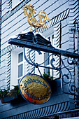 A Sign Hanging From A Building With A Golden Rooster; Hachenburg Rheinland-Pfalz Germany