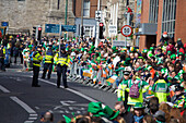 Eine Menschenmenge und die Polizei auf der Straße bei der St. Patrick's Day Parade; Dublin Irland