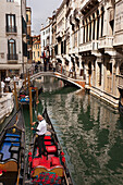 Gondoliere auf einer Gondel in einem Kanal; Venedig Italien