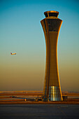 An Airplane Flies Past The Air Traffic Control Tower At The Beijing Airport; Beijing China