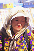 Mongolei, Frau mit Kopftuch im hellen Sonnenlicht; Ulaanbaatar