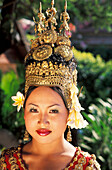 Cambodia, Portrait of woman in traditional dancing costume with greenery in background; Siem Reap