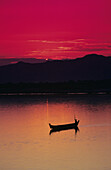 Myanmar (Burma), Bagan, Irrawaddy River, Fisherman In Boat Silhouetted Against Bright Red Sunset.
