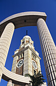 China, Hong Kong, Low angle view of Old Kcr Station Clock Tower through modern structure; Kowloon