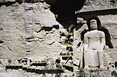 China, Bingling-Si-Höhlen, große in den Berghang gehauene Statue, Treppen führen in und um die Höhlen