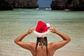 A Woman Tourist Wears A Santa Hat And Bikini On Tropical Matinloc Island Near El Nido And Corong Corong; Bacuit Archipelago On Palawan Philippines