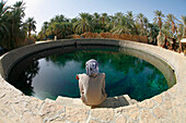 Ein einheimischer Siwaner schaut in Kleopatras Pool, eine natürliche Süßwasserquelle in Siwa in der Oase Siwa; Siwa Ägypten