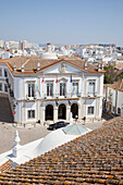 A Car Parked In Front Of A White Building With The City In The Background; Faro Algarve Portugal