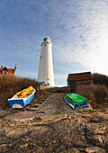 Rowboats Abandoned On The Shore In Front Of The Lighthouse On St. Mary's Island; Northumberland England