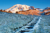 Sunrise Over Mount Rainier And First Autumn Snow Covering Steps Leading Up A Hill; Washington United States Of America