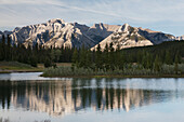 Mountain Range And Lake With Reflection At Sunset; Banff Alberta Canada