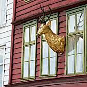 Golden Deer Head Mounted To The Exterior Wall Of A Building; Bergen Norway