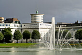 Water Fountain And Buildings Along The Water; Bergen Norway