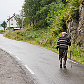 Ein älterer Mann geht die Straße hinauf; Hardangervidda Norwegen