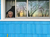 Kontemplative ältere Frau starrt aus dem Fenster
