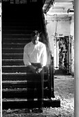 Transparenter Mann steht auf der Treppe eines verlassenen Gebäudes