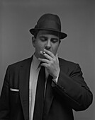 Halblanges Porträt eines Geschäftsmannes, der eine Zigarette raucht