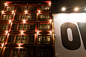 Illuminated Apartment Building with large canvas sign at Night, Madrid, Spain