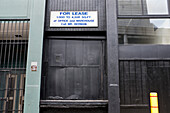 "For Lease" Sign above Black Loading Dock Door