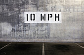 Schild mit Geschwindigkeitsbegrenzung von 10 mph an der Wand eines Parkhauses
