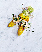 Barbecued corn cobs with beer and cheddar butter