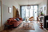 Mixed-style living room with red leather sofa, desk in the background