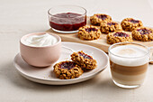 Jam oat cookies served with yogurt and latte macchiato