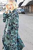 Young blond woman in transitional coat with leaf jacquard