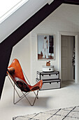 Modern attic flat with designer armchair and white brick walls