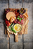 Käseplatte mit Oliven, Dip, Tomaten, Gurken, Trauben und Walnüssen