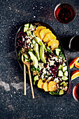 Salad with oranges, cucumber, red cabbage, avocado and feta