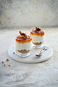 Layered dessert of cookies, whipped cream cheese, apricot jam and caramelized walnuts