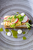 Scrambled eggs with smoked trout and radishes on crispbread