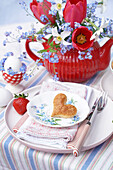 Spring table setting with heart-shaped biscuit and floral decorations