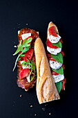 Baguette sandwich with salami and tomato and mozzarella cheese