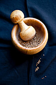 Wooden mortar with coriander seeds
