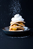 Pancakes with mirabelles, cream and powdered sugar